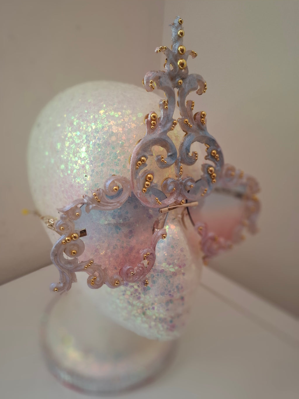 Hand-sculpted sunglasses in iridescent pearl-to-pink-to-blue scrollwork with gold accents.
