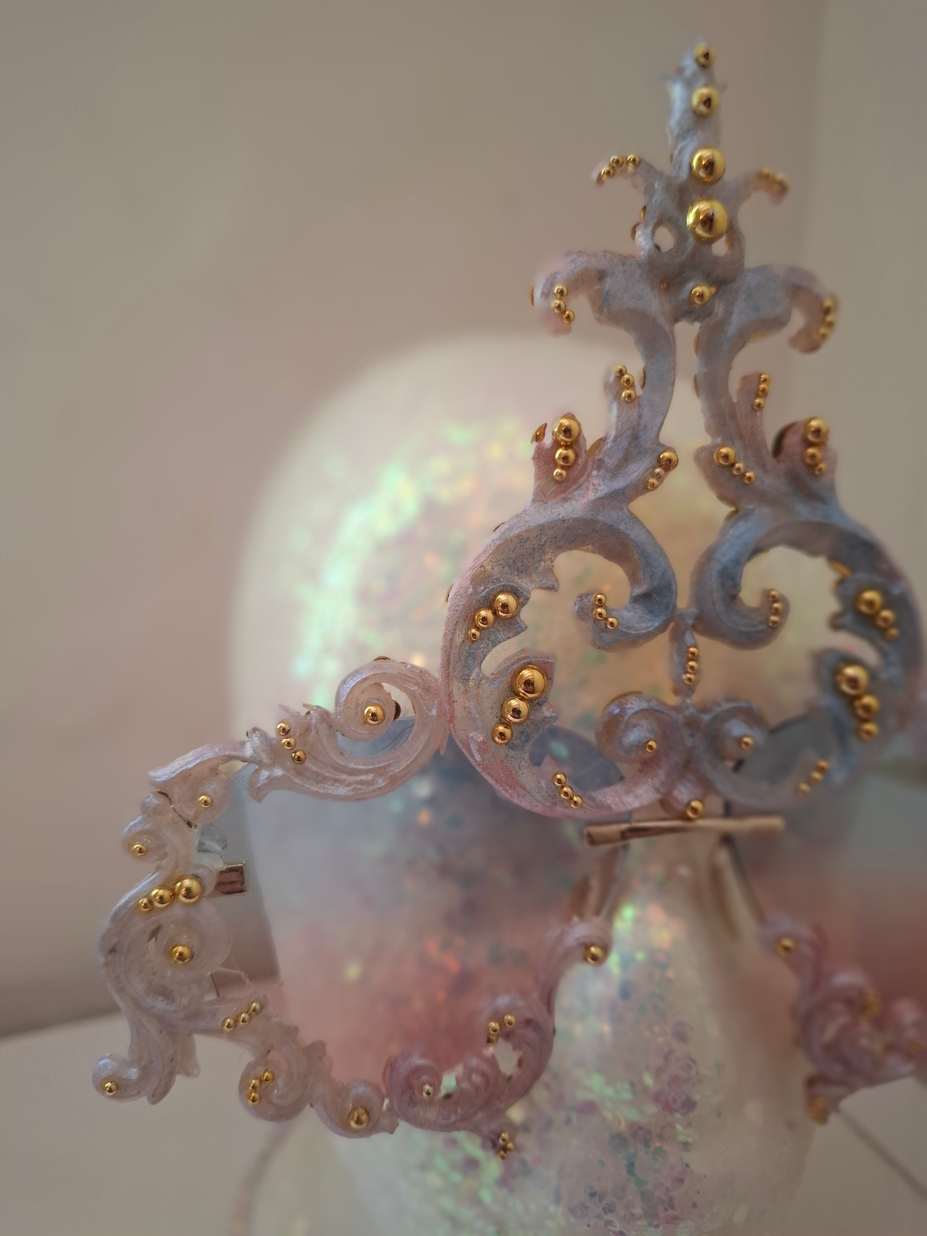 Hand-sculpted sunglasses in iridescent pearl-to-pink-to-blue scrollwork with gold accents.