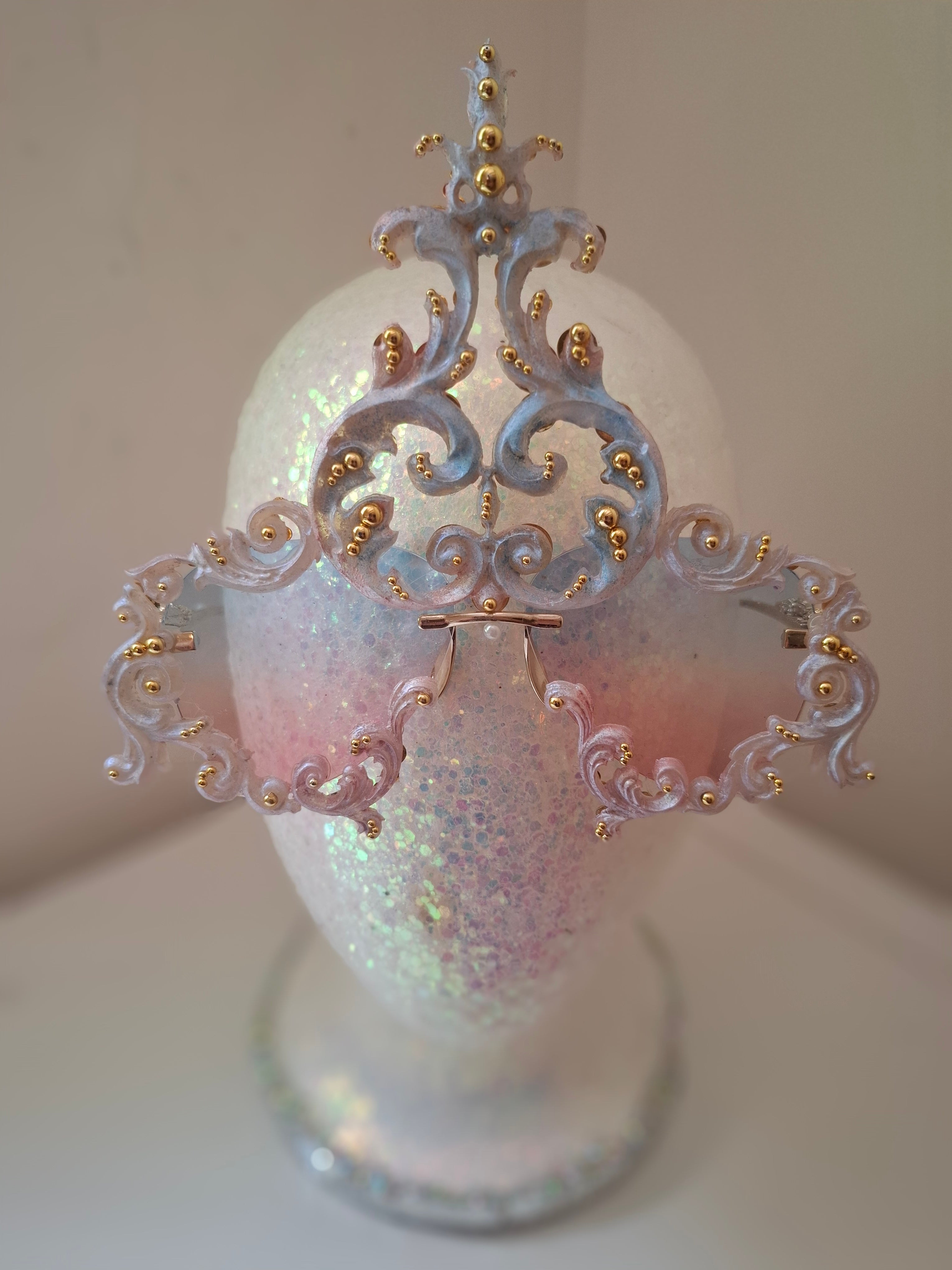 Hand-sculpted sunglasses in iridescent pearl-to-pink-to-blue scrollwork with gold accents.