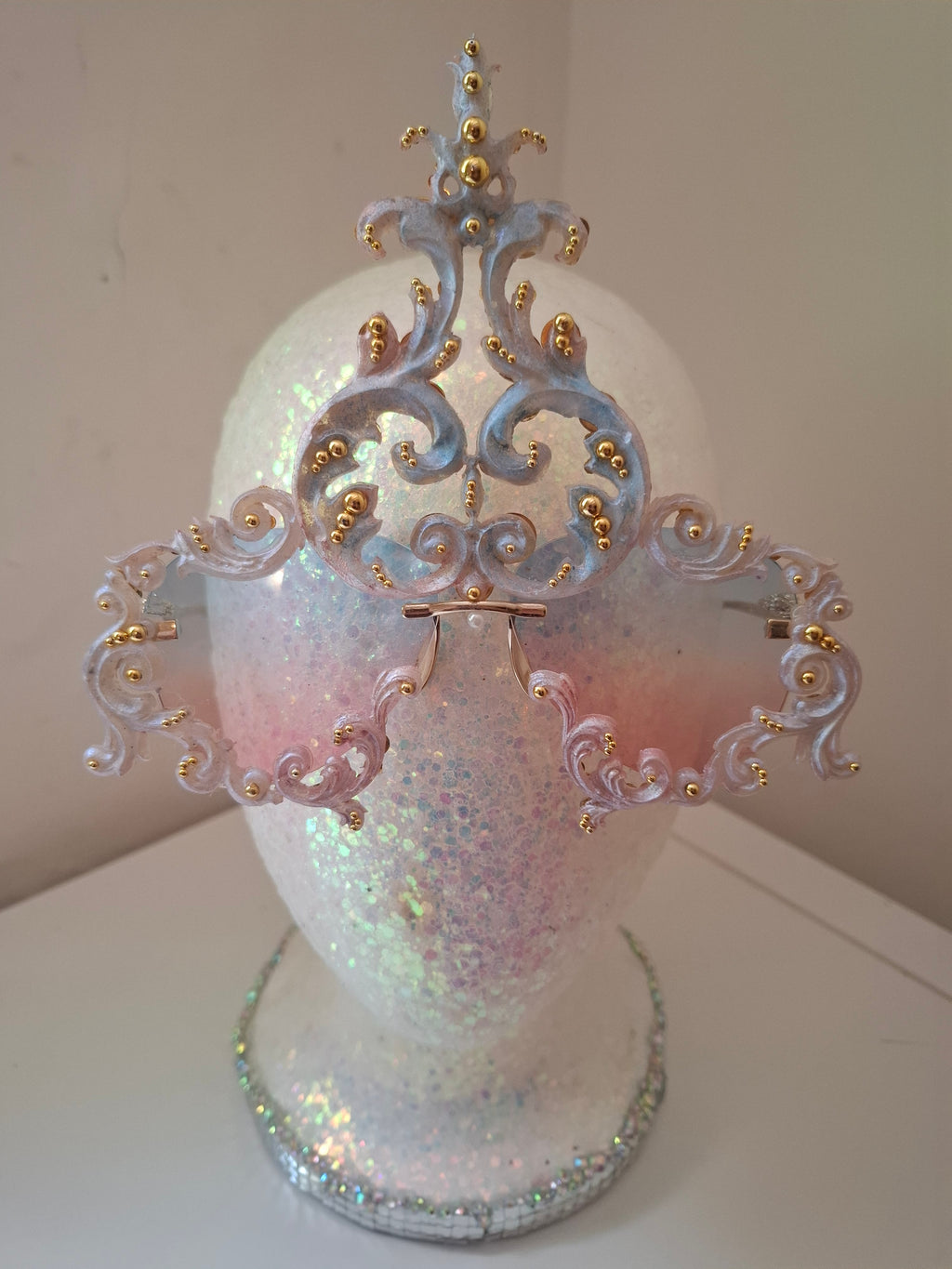 Hand-sculpted sunglasses in iridescent pearl-to-pink-to-blue scrollwork with gold accents.
