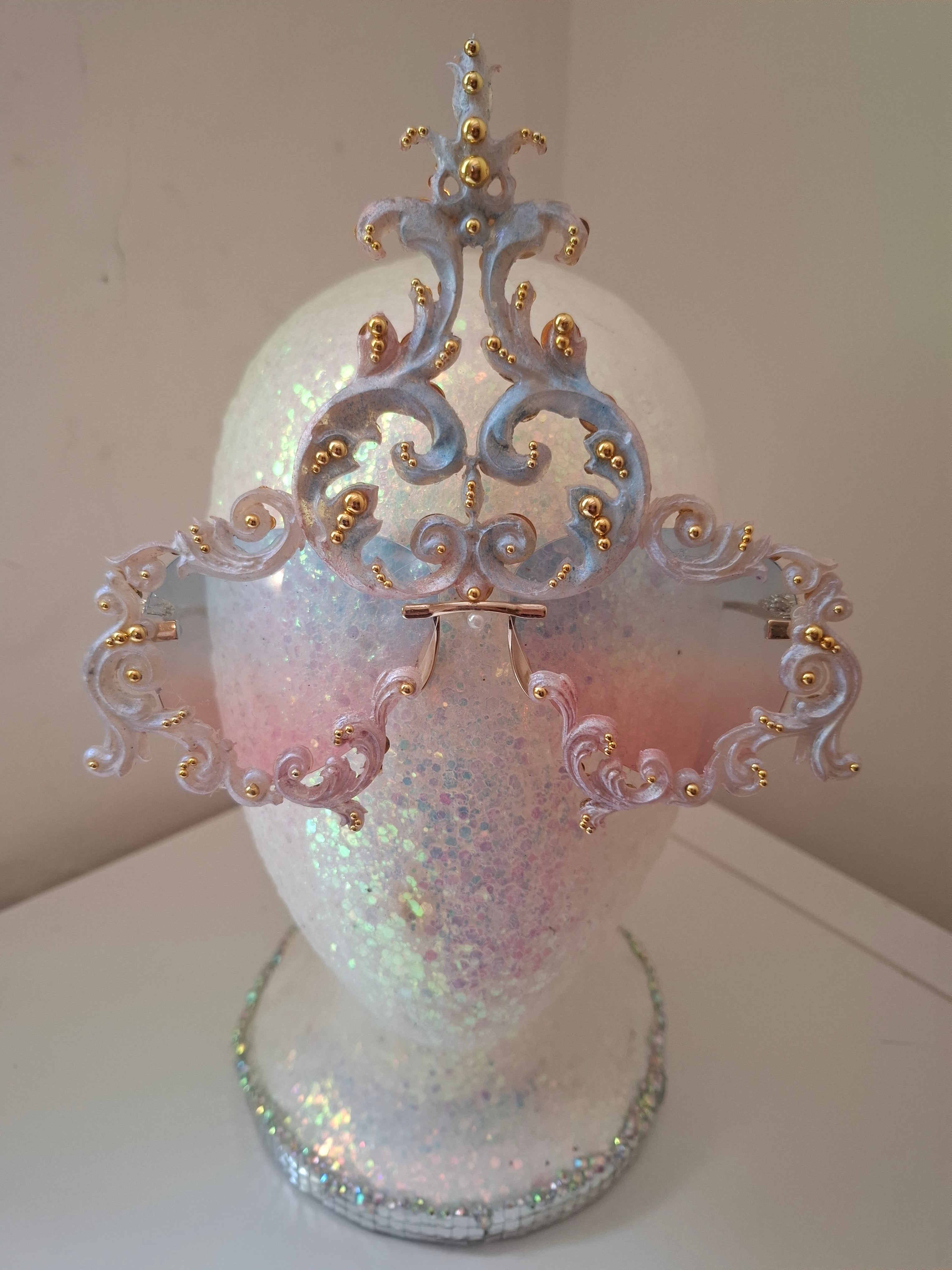 Hand-sculpted sunglasses in iridescent pearl-to-pink-to-blue scrollwork with gold accents.