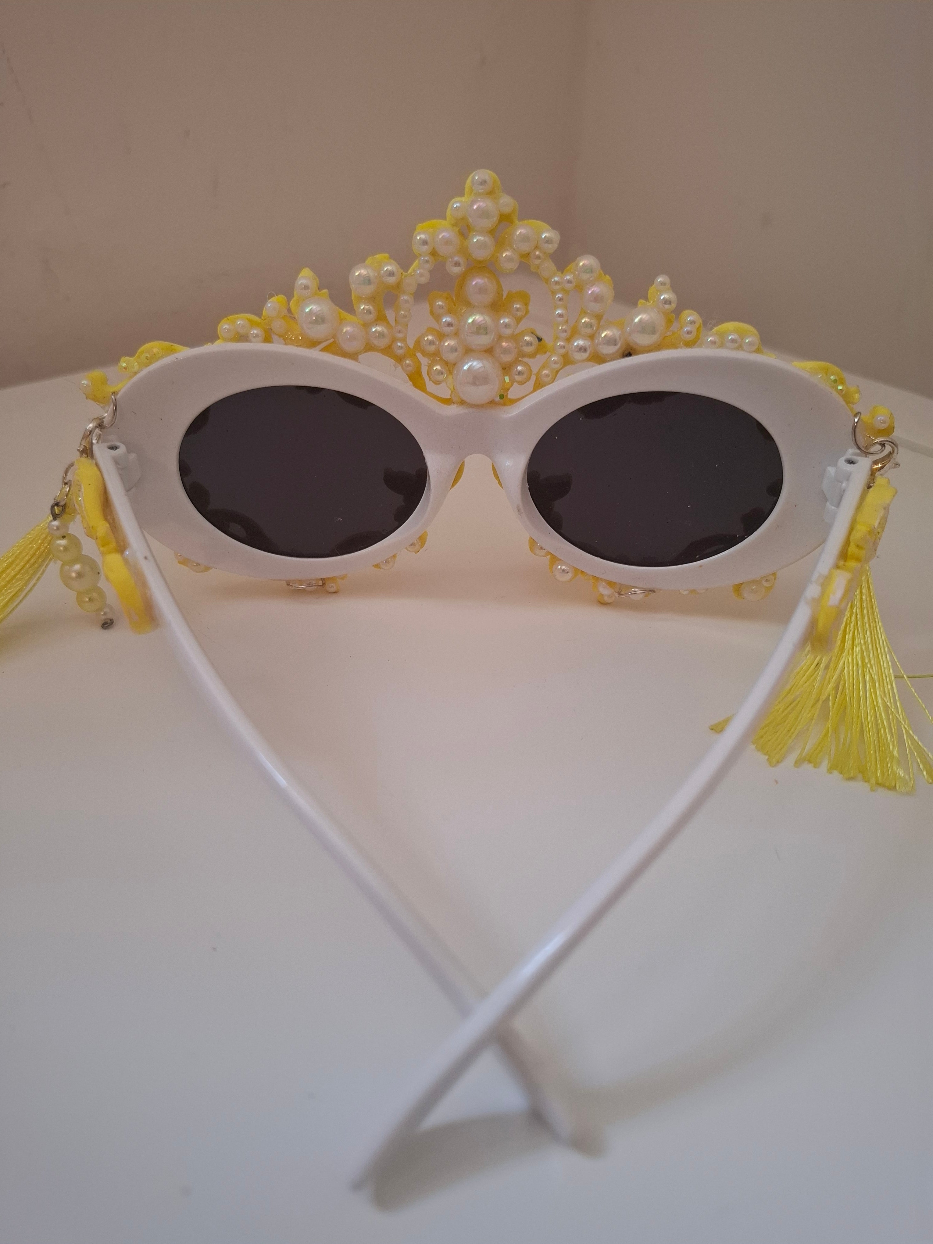  Hand-sculpted sunglasses in gold scrollwork with pearls and tassel drops. 