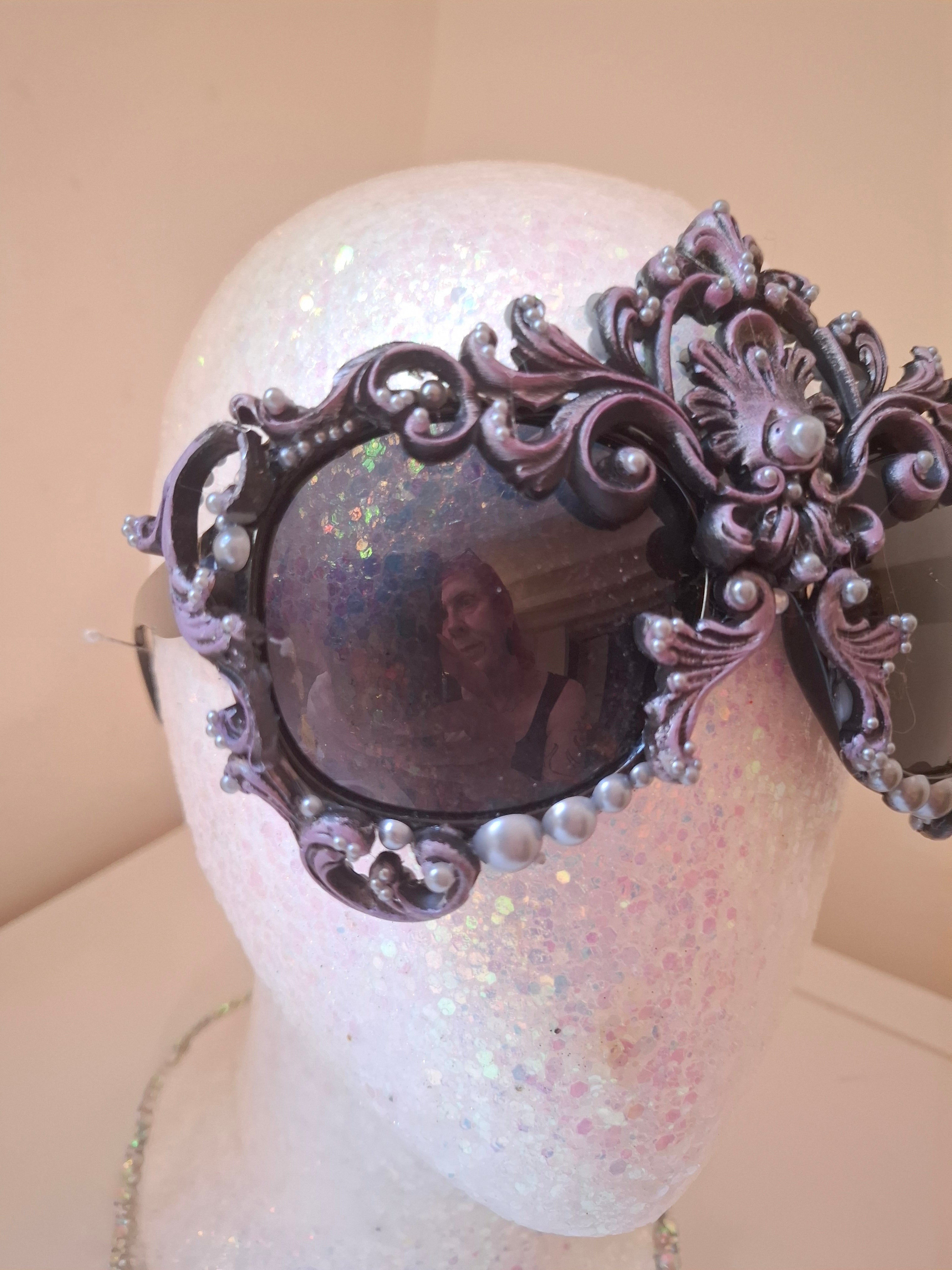  Hand-sculpted sunglasses in deep plum scrollwork with a fleur-de-lis crown and cascading pearl drops. 