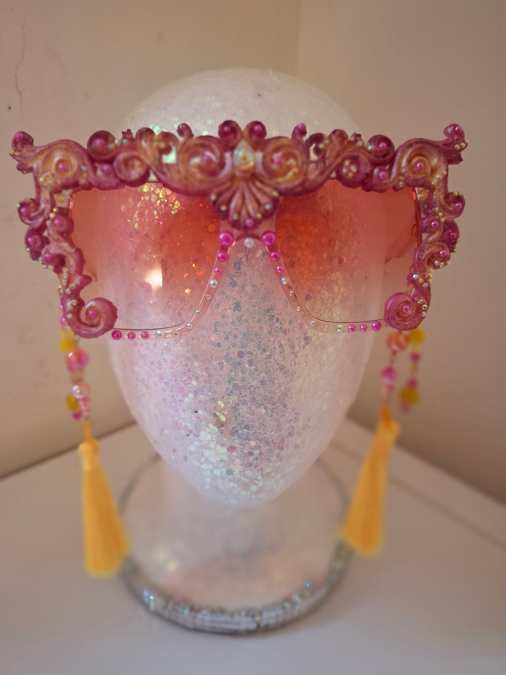 Hand-sculpted sunglasses in warm gold scrollwork with pearls and tassels. 