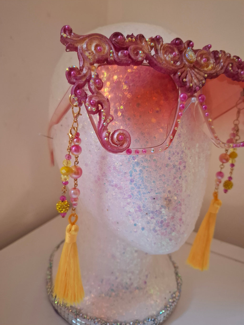 Hand-sculpted sunglasses in warm gold scrollwork with pearls and tassels. 