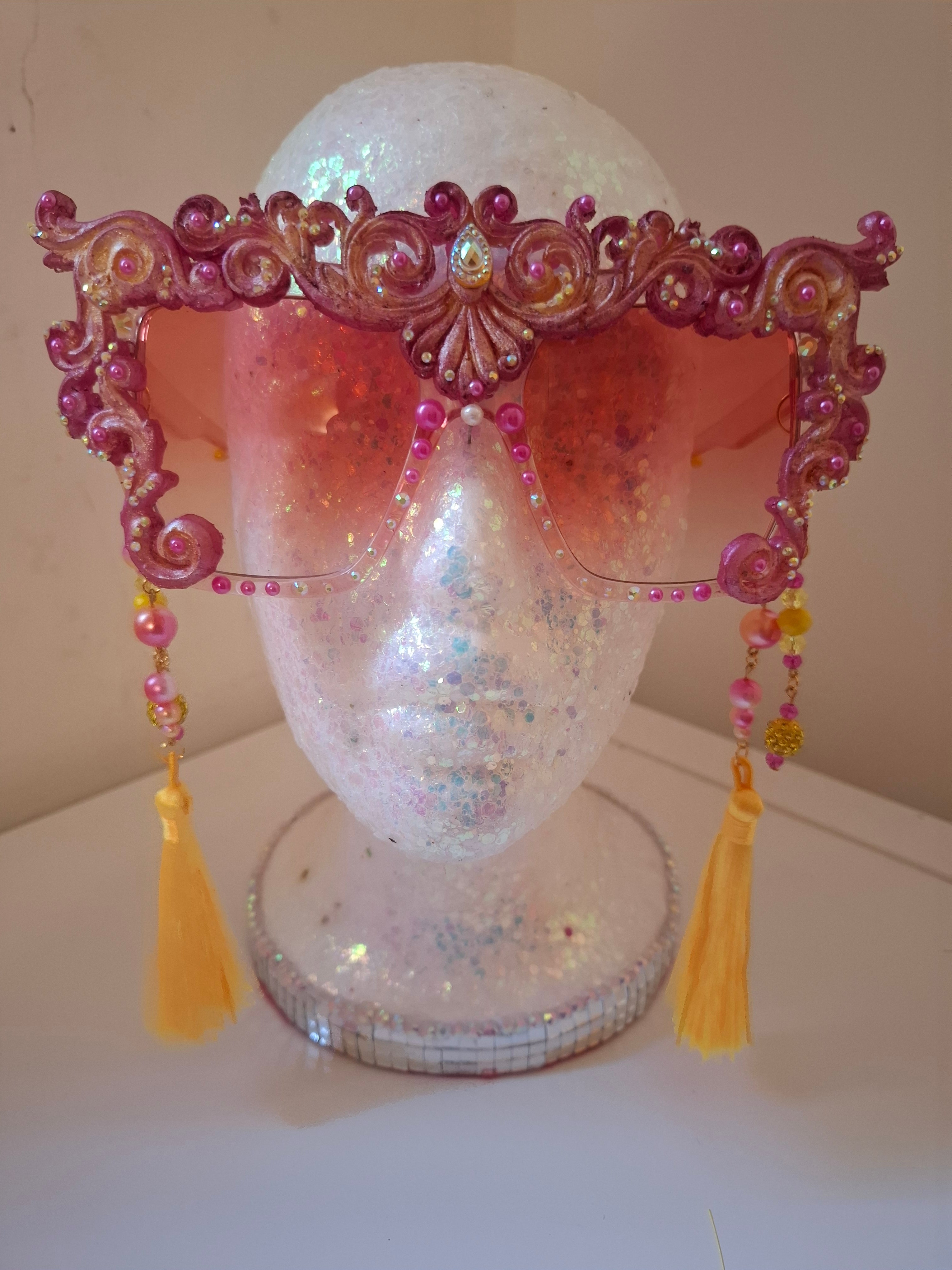 Hand-sculpted sunglasses in warm gold scrollwork with pearls and tassels. 