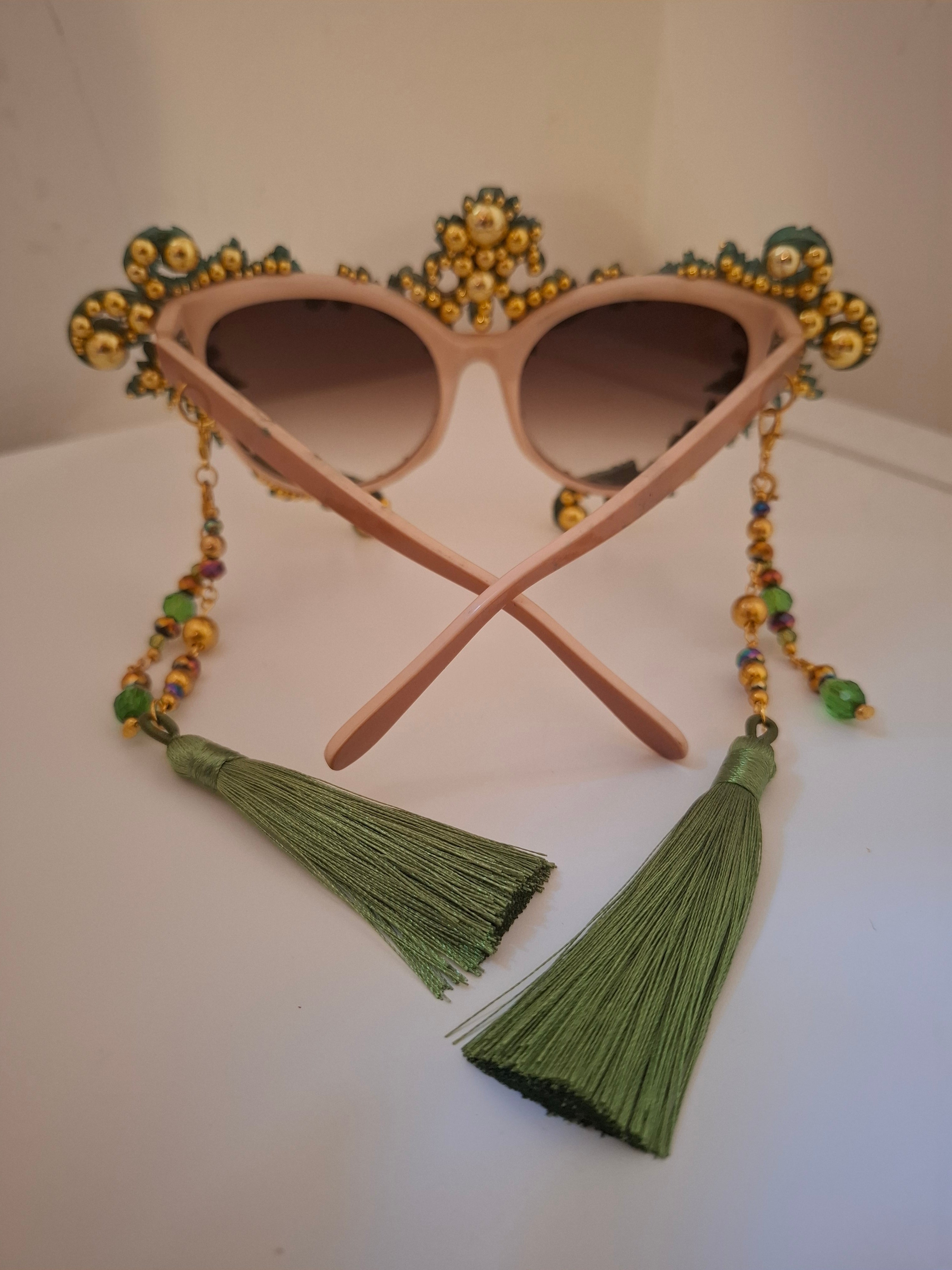 Hand-sculpted sunglasses in copper and forest green verdigris scrollwork with golden accents and emerald tassels.