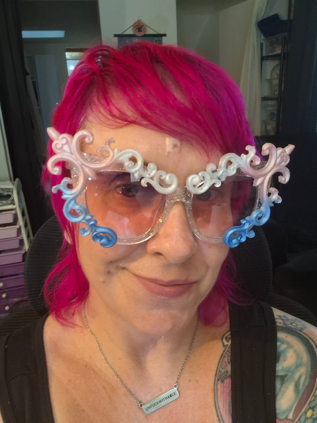 Hand-sculpted Pride sunglasses in trans flag colors — pink, white, and blue, with beaded tassels.

