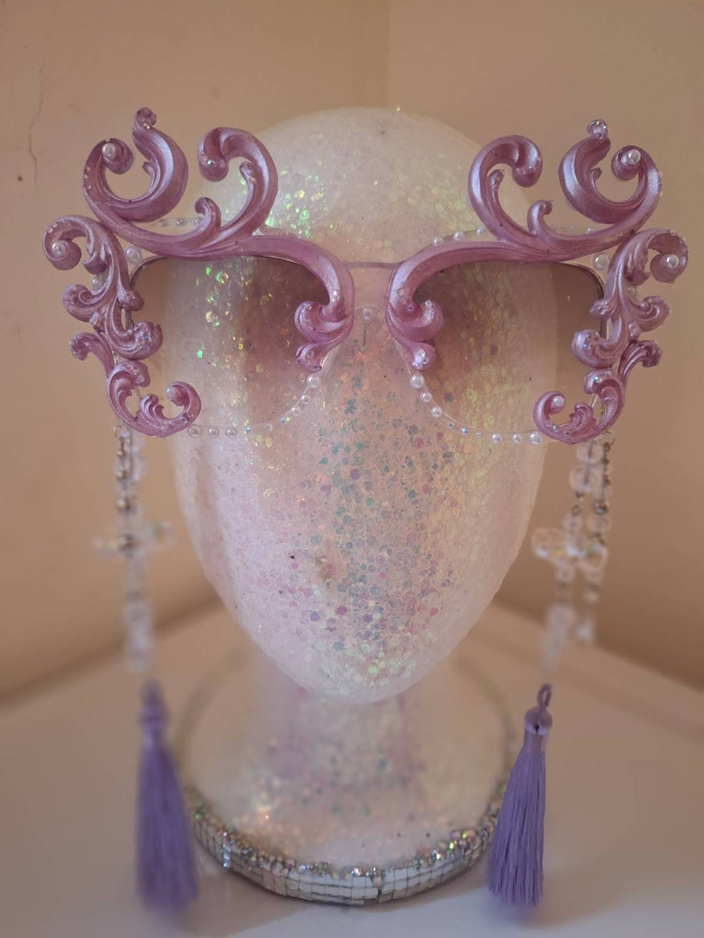 Hand-sculpted sunglasses in soft lavender scrollwork with opalescent pearls and lilac tassels.